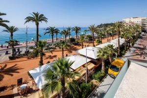 an aerial view of a beach with palm trees and a yellow van at URH Excelsior in Lloret de Mar