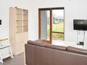 a living room with a couch and a tv at 8 person holiday home in Ulfborg-By Traum in Thorsminde