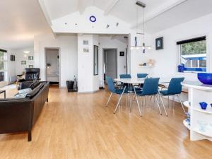 a living room with a table and blue chairs at Seaside Charm in Nature - By Traum Ferienwohnungen in Helberskov