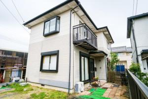 a white house with black windows and a balcony at Villa228KASAMA - Vacation STAY 92175v in Kasama
