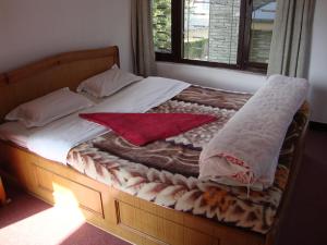 a bed with two pillows and avertisement at New Summit Guest House in Pokhara