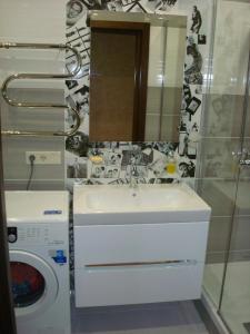 a bathroom with a sink and a washing machine at Apartment on Privokzalnaya 2/1 in Vinnytsya