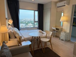 ein Wohnzimmer mit einem Bett und einem Tisch und Stühlen in der Unterkunft Cozy5Living in Bangkok 60m to MRT near chatuchank in Ban Bang Khwang