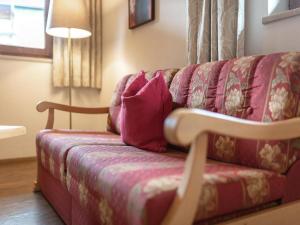 Un sofá rojo con una almohada rosa. en Apartment in Fügen near Spieljochbahn, en Fügen