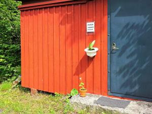 a redshed with a plant in a pot next to a door at 5 person holiday home in TINGSRYD-By Traum in Tingsryd