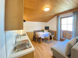 cocina y sala de estar con fregadero y mesa en Apartment in Filzmoos near Ski Amadé, en Filzmoos