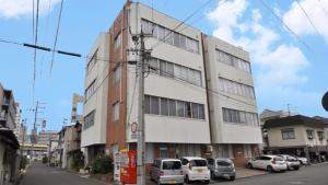 un edificio con auto parcheggiate di fronte ad esso in una strada di Hotel Itakura - Vacation STAY 70058v a Fukushima
