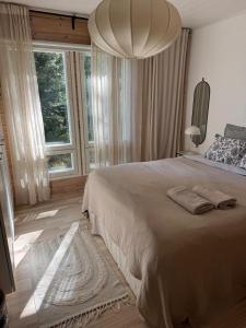 a bedroom with a large bed and a large window at Villa Laidike with sauna/fireplace, 80 km Helsinki in Suomusjärvi