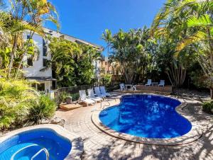 a swimming pool in a yard with palm trees at Cabarita Beachfront Ocean View 12 in Cabarita Beach
