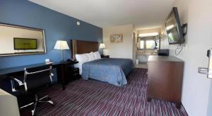 a hotel room with a bed and a television at Econo Lodge Inn & Suites in Enid