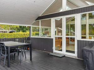 a screened in porch with a table and chairs at 4 star holiday home in Hovborg in Hovborg
