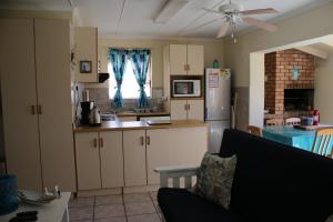 a kitchen with a couch and a kitchen with a refrigerator at 28 Kabeljauws in Jeffreys Bay