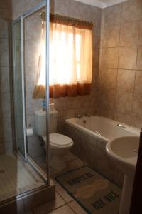 a bathroom with a toilet and a tub and a sink at 28 Kabeljauws in Jeffreys Bay