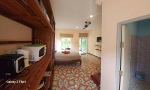 ein Schlafzimmer mit einem Bett und einem Fernseher in einem Zimmer in der Unterkunft Cozy Apartment Kitchen 1 in Ban Mo Nae