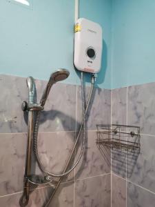 einem Duschkopf mit einem Schlauch an der Wand in der Unterkunft Cozy Apartment Kitchen 1 in Ban Mo Nae
