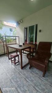 Zimmer mit einem Holztisch, einer Bank, einem Tisch und einem Stuhl in der Unterkunft Cozy Apartment Kitchen 1 in Ban Mo Nae