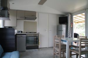 a kitchen with a table and a kitchen with a stove at Village Vacances Bonne Anse Plage in La Palmyre