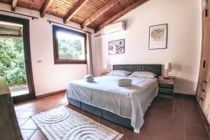 a bedroom with a bed and a large window at Villa Blu splendida villa con piscina - Stintino Sardegna in Cuile Pazzoni