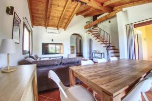 a living room with a wooden table and white chairs at Villa Blu splendida villa con piscina - Stintino Sardegna in Cuile Pazzoni +43 photos
