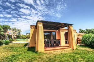 a patio with a table and chairs in a yard at Villa Blu splendida villa con piscina - Stintino Sardegna in Cuile Pazzoni