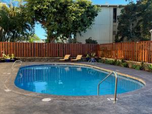a swimming pool in a yard with a fence at Holualoa Gardens 204 in Kailua-Kona