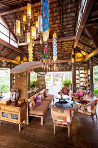 a living room with couches and chairs in a building at Sibsan Resort & Spa Maetaeng Chiang Mai in Mae Taeng