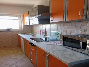 a kitchen with orange cabinets and a counter top at Apartment in Senj near the Sea & Pool in Senj