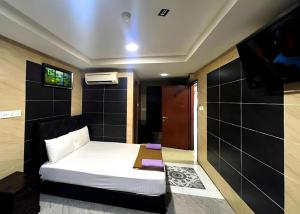 a bedroom with a bed and a flat screen tv at Kota Damansara Business Hotel in Kepong Cubitt Forest Village