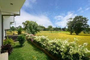 a garden of flowers with a field in the background at Polaris- Kurunegala in Kurunegala