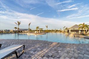 una gran piscina con palmeras y un banco en GRH14692 - Charlotte Harbor Area - 3 Bed 3 Baths Villa, en Tropical Gulf Acres