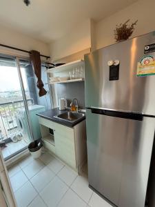 eine Küche mit einem Kühlschrank aus Edelstahl und einer Spüle in der Unterkunft Cozy7 Living in Bangkok60 m to MRTnear chatuchank in Ban Bang Khwang