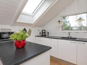 a kitchen with a black counter top and a window at 6 person holiday home in Ålbæk-By Traum in Ålbæk