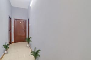 un pasillo con dos macetas delante de una puerta en Hotel O FOURTEEN, en Kondapur
