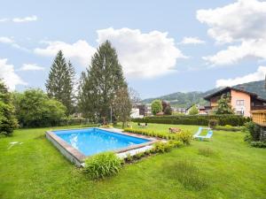 a swimming pool in a yard with a grass field at Apartment in Tröpolach near Nassfeld in Tröpolach