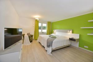 een slaapkamer met een bed en een groene muur bij Ferienwohnung Strandkörbchen in Juliusruh
