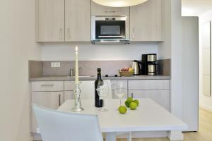 una cocina con una mesa blanca con velas y copas de vino en Ferienwohnung Strandkörbchen, en Juliusruh