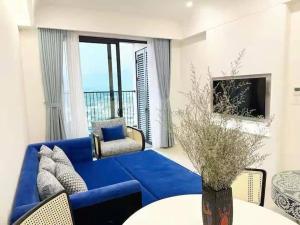 a living room with a blue couch and a tv at Hillside residence Phu Quoc, sea &firework view in Phu Quoc