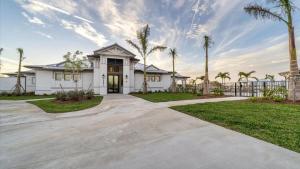 a house with palm trees and a driveway at GRH14653 - Charlotte Harbor Area - 2 Bed 2 Baths Condo in Tropical Gulf Acres