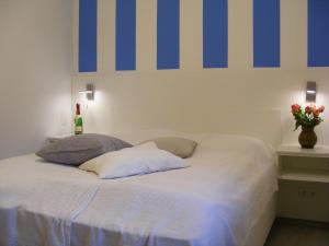 Schlafzimmer mit einem Bett mit blauen Streifen an der Wand in der Unterkunft Ferienzimmer Lütt in Juliusruh