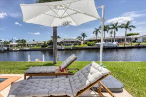 a couple of chairs and an umbrella next to a body of water at GRH14284 - Charlotte Harbor Area - 2 Bed 2 Baths Villa in Punta Gorda Isles
