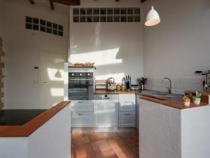 a kitchen with white cabinets and an oven in it at Villa in Cortona with Private Pool in Magione
