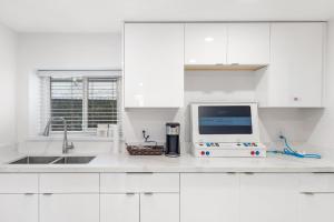 a kitchen with white cabinets and a computer on a counter at Callister BNB in Vancouver