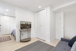a living room with white walls and a tv on a table at Callister BNB in Vancouver