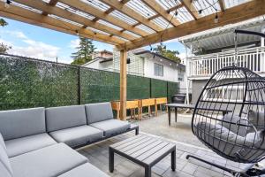 a patio with a couch and a swing at Callister BNB in Vancouver