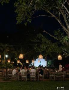 a group of people sitting at tables at night at Casa da Cristina in Trancoso