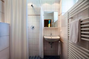 a small bathroom with a sink and a shower at Thermenhotel Krone - inklusive Felsentherme in Bad Gastein +54 photos