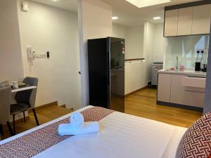 Habitación con cama y cocina con nevera. en The Colony By Infinitum KLCC - Aura Suites, en Kuala Lumpur