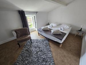 a bedroom with a bed and a chair at Chez Sandrine in Angoulême