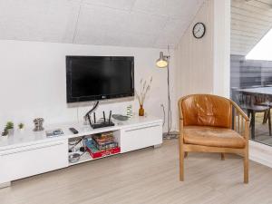a living room with a chair and a flat screen tv at 6 person holiday home in Thisted-By Traum in Torsted