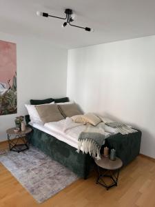 a bed in a white room with two tables at NEU! moderne Stadtwohnung in Ulm-Söflingen in Ulm